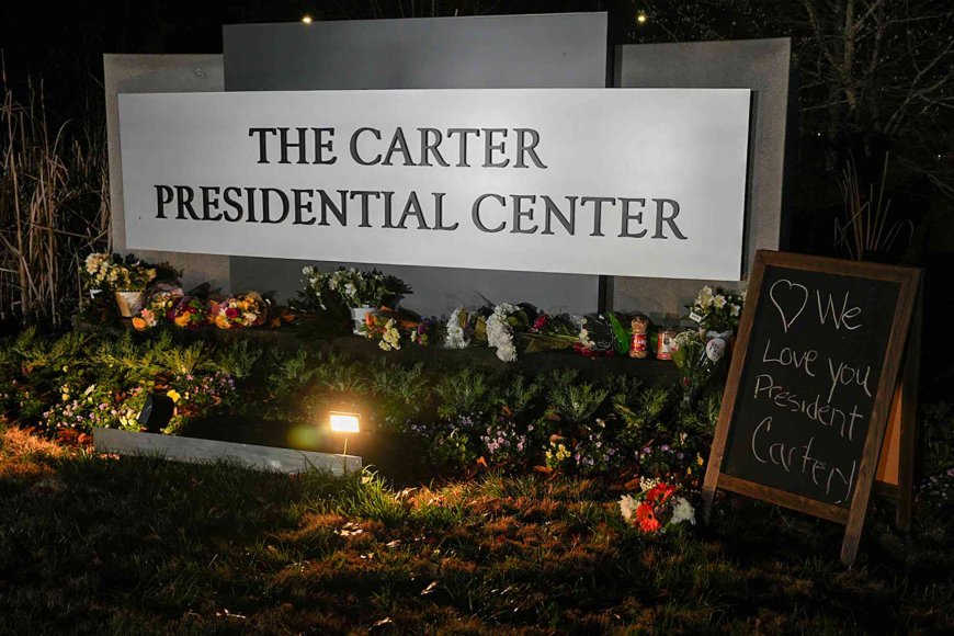 Mourners Place Peanuts, Peaches and Even Peanut Butter Outside of Carter Center Following Jimmy Carter's Death